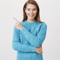 Portrait of surprised excited caucasian female pointing at upper left corner, being impressed with what she saw, standing over gray background. Girl on show can not believe her eyes. Advertisement concept.